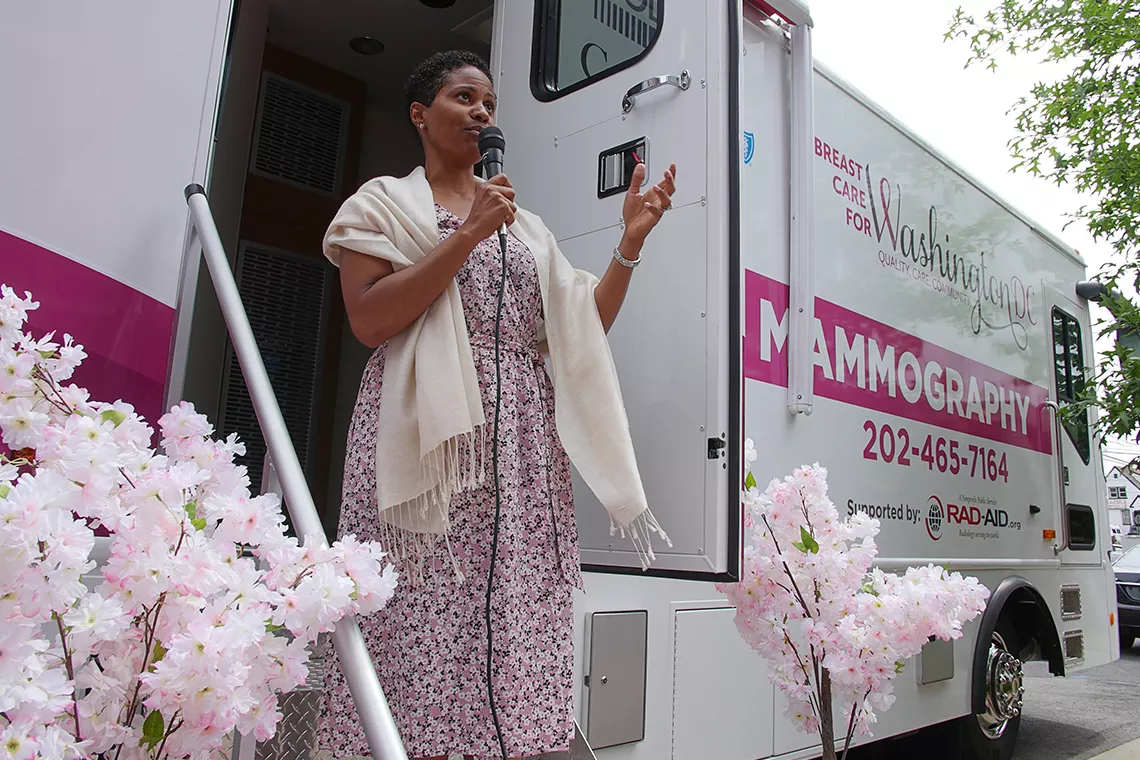 Black female talking into microphone standing in front of the MobileMammo bus